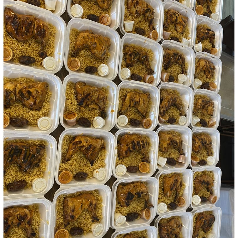 Rows of Port of Peri Peri chicken and rice meals in white takeout containers.